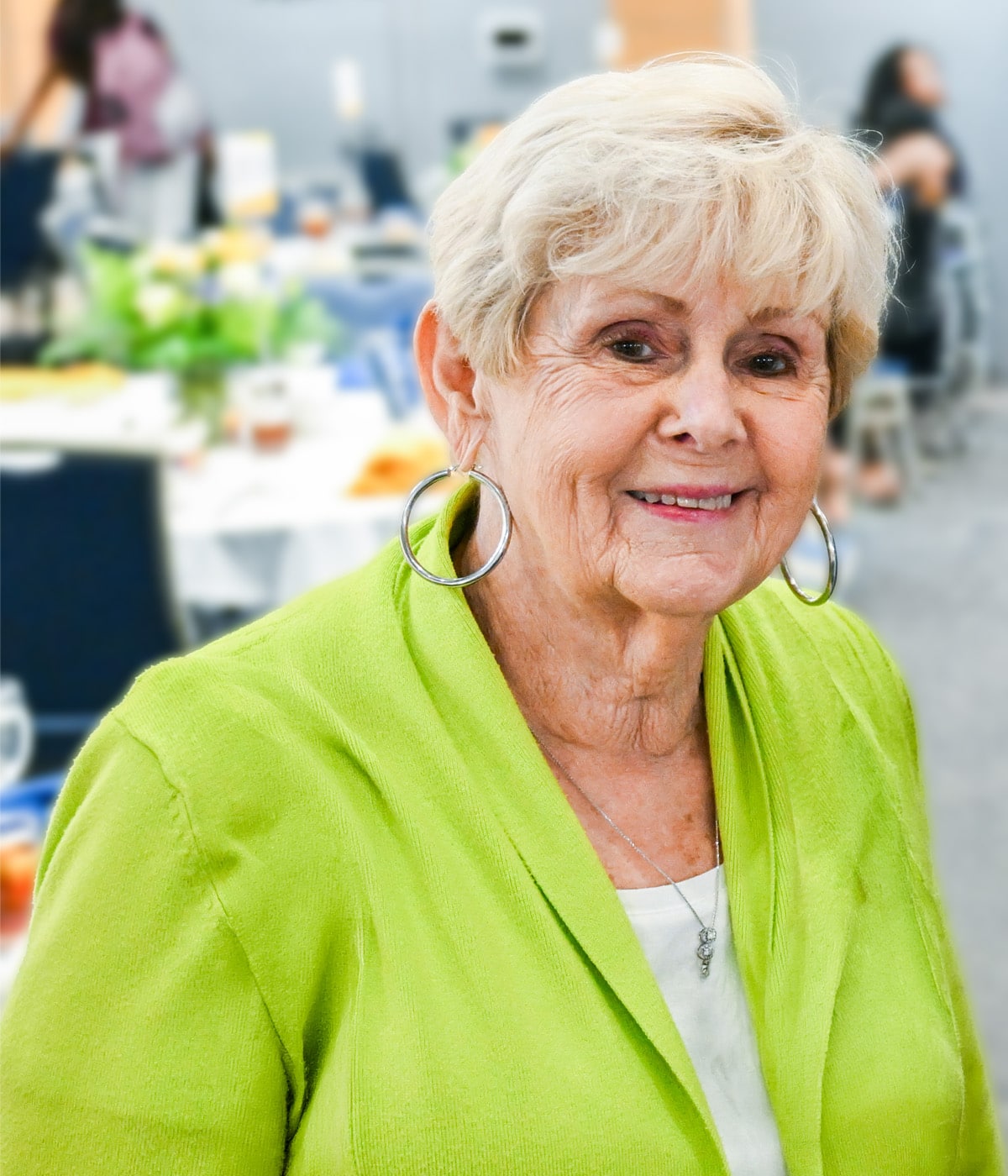Movita Steiner in a green sweater with tables in the background. 